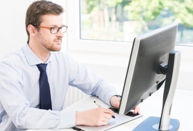 Modern bir ofiste çalışan genç işadamı