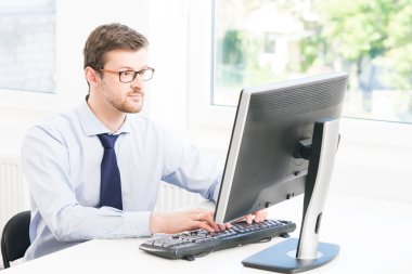 Modern bir ofiste çalışan genç işadamı