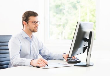 Modern bir ofiste çalışan genç işadamı