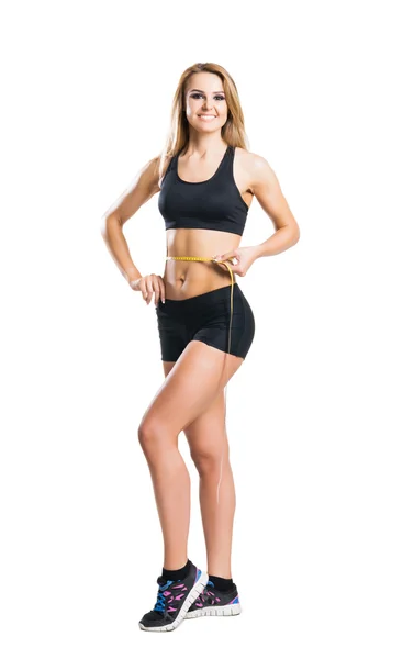 Sporty woman in sportswear measuring her body isolated on white — Stock Photo, Image