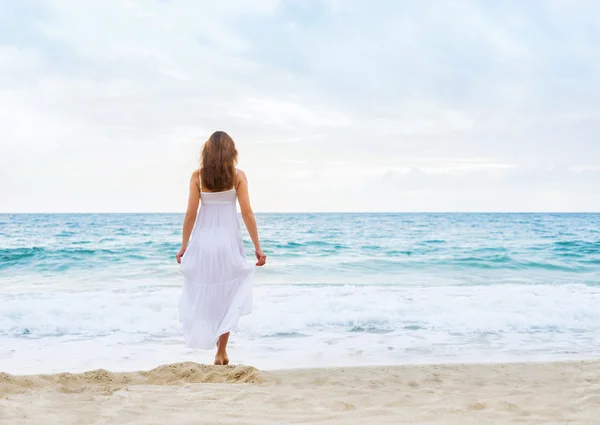 Mulher em um vestido branco na praia — Fotografia de Stock