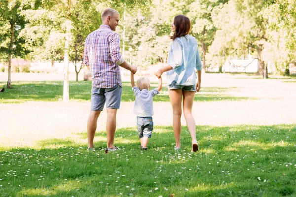 Madre y padre sosteniendo a su hijo en el aire — Foto de Stock