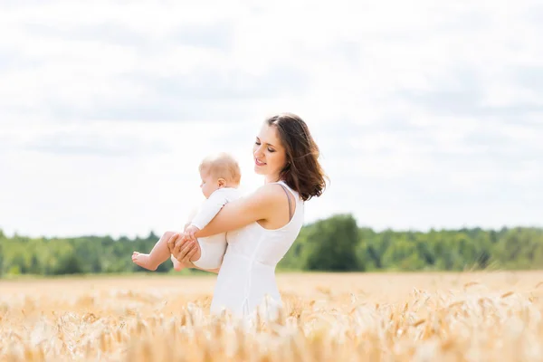 Žena s dítětem kojenecká v poli — Stock fotografie