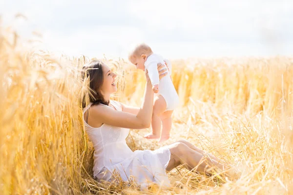 Vrouw met haar baby baby in een veld Stockfoto