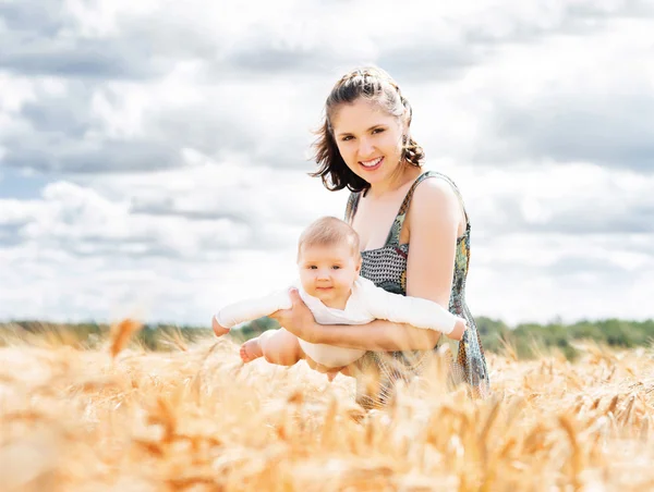 Žena s dítětem kojenecké na louce — Stock fotografie