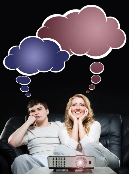 Couple watching a movie or a sport broadcast on a laser projector — Stock Photo, Image