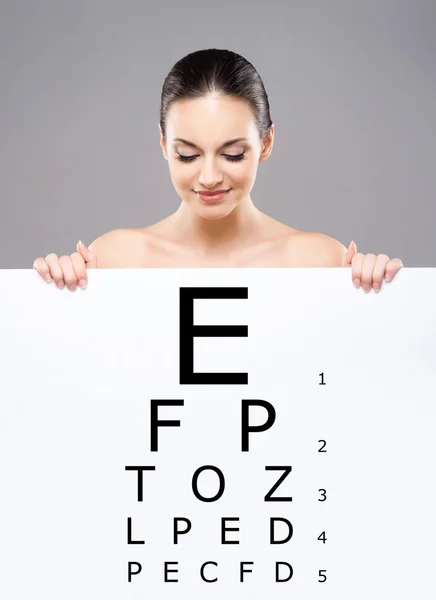 Woman with abanner of test vision table — Stock Photo, Image