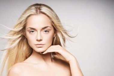 Saf deri gri arka plan üzerinde poz ile muhteşem sarışın.