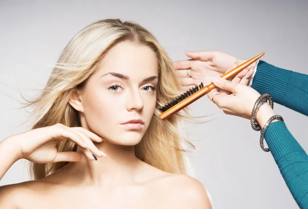 Jovem mulher loira recebendo seu cabelo estilo — Fotografia de Stock