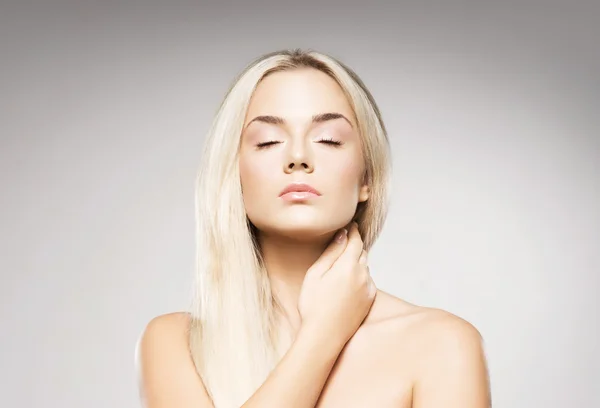 Blonde vrouw met zuivere huid poseren op een grijze achtergrond — Stockfoto