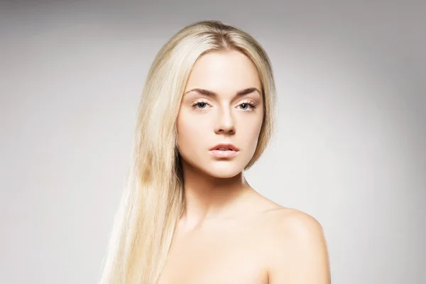 Блондинка з чистою шкірою позує на сірому фоні — стокове фото
