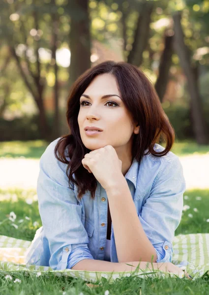 Portrait of a young brunette woman in the park — Stock Photo, Image