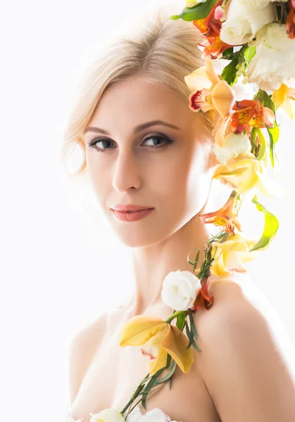 Portret van een jonge bruid in een witte jurk poseren met bloemen — Stockfoto