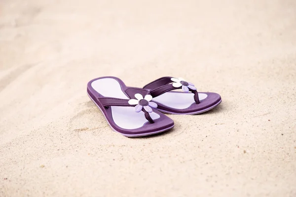 Närbild av lila flip-flops på sanden — Stockfoto