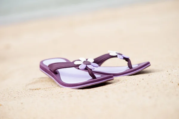 Vackra lila flip-flops på stranden — Stockfoto