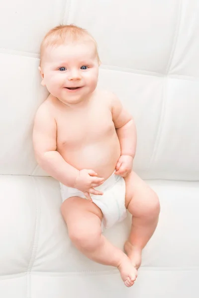 Retrato de um bebê infantil sorridente bonito em uma fralda — Fotografia de Stock