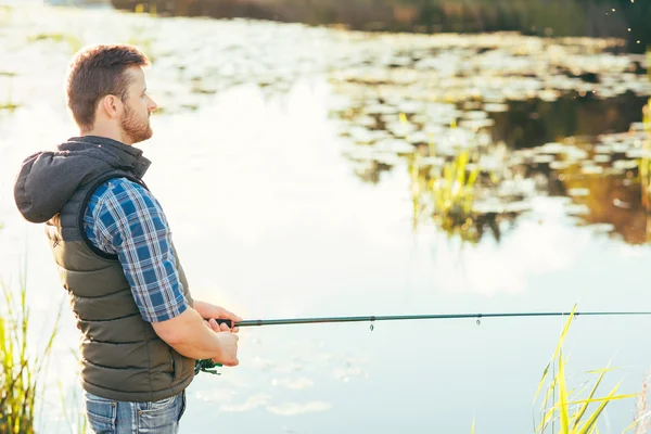 Visser met een staaf van de spinnen vangen van vis in een rivier — Stockfoto