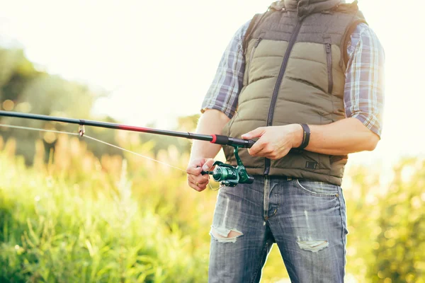 Fisherman with spinning rod — Stock Photo, Image