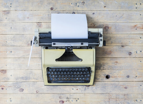 Retro typewriter over wooden background