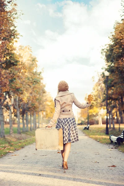 Vacker flicka med resväska i park — Stockfoto