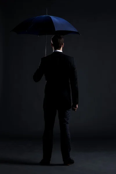 Бизнесмен с голубым зонтиком — стоковое фото