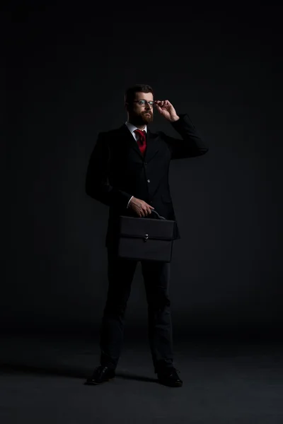 Jonge zakenman op donkere achtergrond — Stockfoto