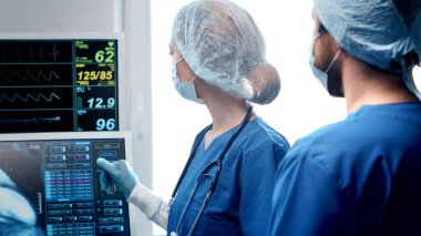 Acil tıpta çalışan profesyonel tıp doktorları. Cerrah ve koruyucu maskeli hemşirenin portresi cerrahi operasyon gerçekleştiriyor..