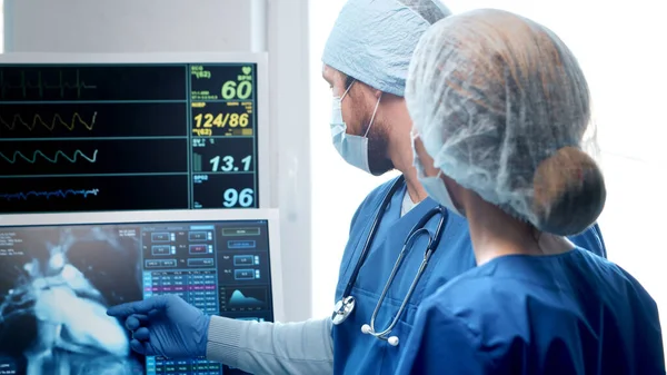 Professional medical doctors working in emergency medicine. Portrait of the surgeon and the nurse in protective masks performing surgical operation. — Stock Photo, Image