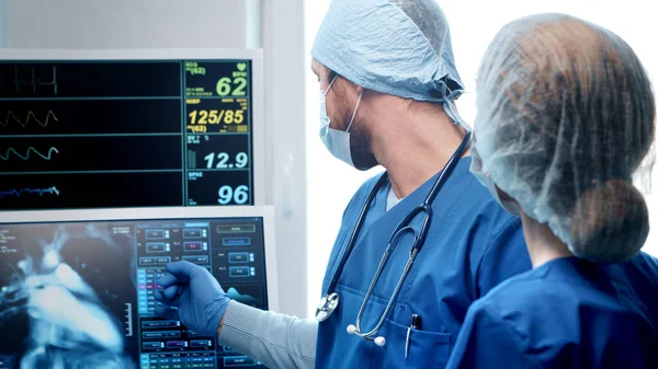 Professional medical doctors working in emergency medicine. Portrait of the surgeon and the nurse in protective masks performing surgical operation. — Stock Photo, Image