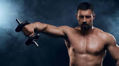Siyah arka planda formda ve sportif vücut geliştirici. Beyaz tenli sporcu stüdyoda. Spor ve spor kavramları.