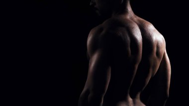 Siyah arka planda formda ve sportif vücut geliştirici. Beyaz tenli sporcu stüdyoda. Spor ve spor kavramları.