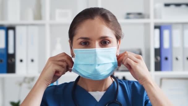病院のオフィスでの専門医 保護マスクで若く魅力的な女性医師の肖像画 医学的概念 — ストック動画