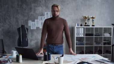 Genç ve yetenekli moda tasarımcılarının işyeri. Terzi şık çatı katında tek başına çalışıyor. Kıyafet çizimleri kullanıyor..