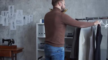 Genç ve yetenekli moda tasarımcılarının işyeri. Terzi şık çatı katında tek başına çalışıyor. Kıyafet çizimleri kullanıyor..