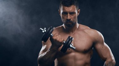 Siyah arka planda formda ve sportif vücut geliştirici. Beyaz tenli sporcu stüdyoda. Spor ve spor kavramları.