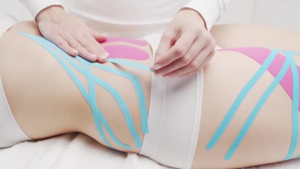 セラピストは女性の体にKinesioテープを適用しています 理学療法 運動療法と回復治療 — ストック動画