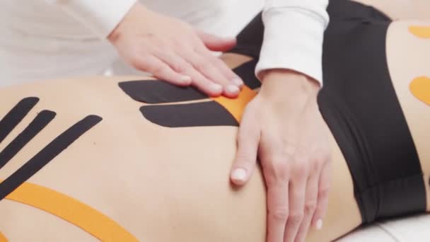 Therapeut Brengt Kinesio Tape Aan Vrouwelijk Lichaam Fysiotherapie Kinesiologie Herstelbehandelingsconcepten — Stockvideo