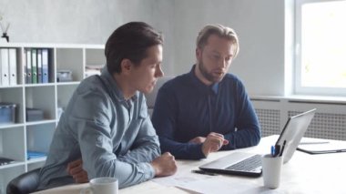 Modern ofiste iki iş adamı birlikte çalışır. İş adamlarından oluşan bir ekip beyin fırtınası yapıyor. Başlangıç ve eşçalışma kavramları.