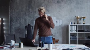 Genç ve yetenekli moda tasarımcılarının işyeri. Terzi şık çatı katında tek başına çalışıyor. Kıyafet çizimleri kullanıyor..