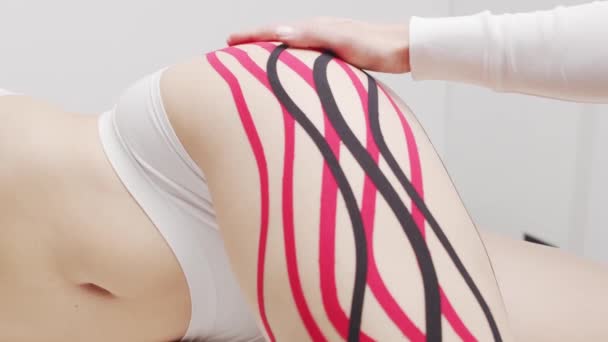 Therapeutin Klebt Kinesiotape Auf Den Weiblichen Körper Physiotherapie Kinesiologie Und — Stockvideo