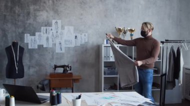 Genç ve yetenekli moda tasarımcılarının işyeri. Terzi şık çatı katında tek başına çalışıyor. Kıyafet çizimleri kullanıyor..