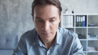 İşadamı bilgisayar teknolojisini kullanarak modern ofiste tek başına çalışıyor. Genç ve kendinden emin iş adamının işyeri..