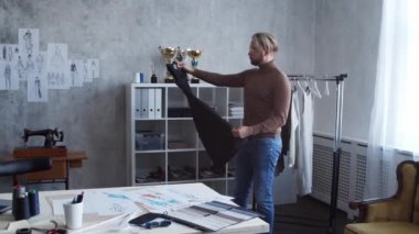 Genç ve yetenekli moda tasarımcılarının işyeri. Terzi şık çatı katında tek başına çalışıyor. Kıyafet çizimleri kullanıyor..