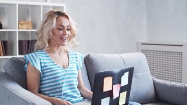 Genç ve çekici bir kadın evde dizüstü bilgisayar kullanarak çalışıyor. Serbest çalışan ya da öğrenci çevrimiçi konuşma yapıyor. Kilitleme kavramı.