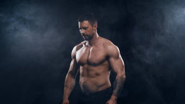 Siyah arka planda formda ve sportif vücut geliştirici. Beyaz tenli sporcu stüdyoda. Spor ve spor kavramları.