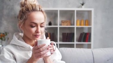 Sabahları evde genç ve çekici bir kadın. Happy Freelancer ya da öğrenci kahve içiyor. Kilitleme kavramı.