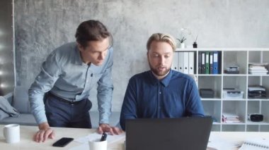 Modern ofiste iki iş adamı birlikte çalışır. İş adamlarından oluşan bir ekip beyin fırtınası yapıyor. Başlangıç ve eşçalışma kavramları.
