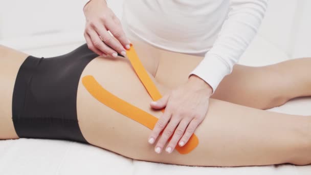 Therapeut Brengt Kinesio Tape Aan Vrouwelijk Lichaam Fysiotherapie Kinesiologie Herstelbehandelingsconcepten — Stockvideo