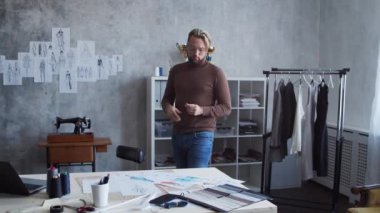 Genç ve yetenekli moda tasarımcılarının işyeri. Terzi şık çatı katında tek başına çalışıyor. Kıyafet çizimleri kullanıyor..