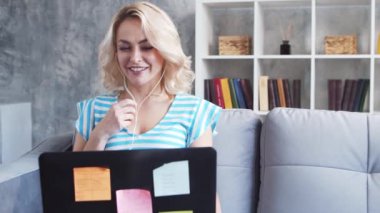 Genç ve çekici bir kadın evde dizüstü bilgisayar kullanarak çalışıyor. Serbest çalışan ya da öğrenci çevrimiçi konuşma yapıyor. Kilitleme kavramı.